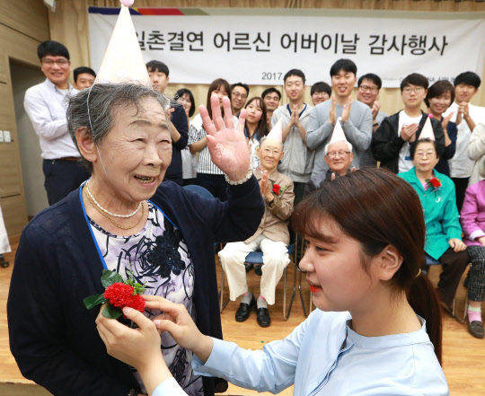 지난 6일 강서구 등촌4종합사회복지관에서 진행한 '어버이날 행사'에서 아시아나항공 직원 자녀들이 결연 대상 독거노인들의 가슴에 카네이션을 달아드리고 있다.  아시아나항공 제공